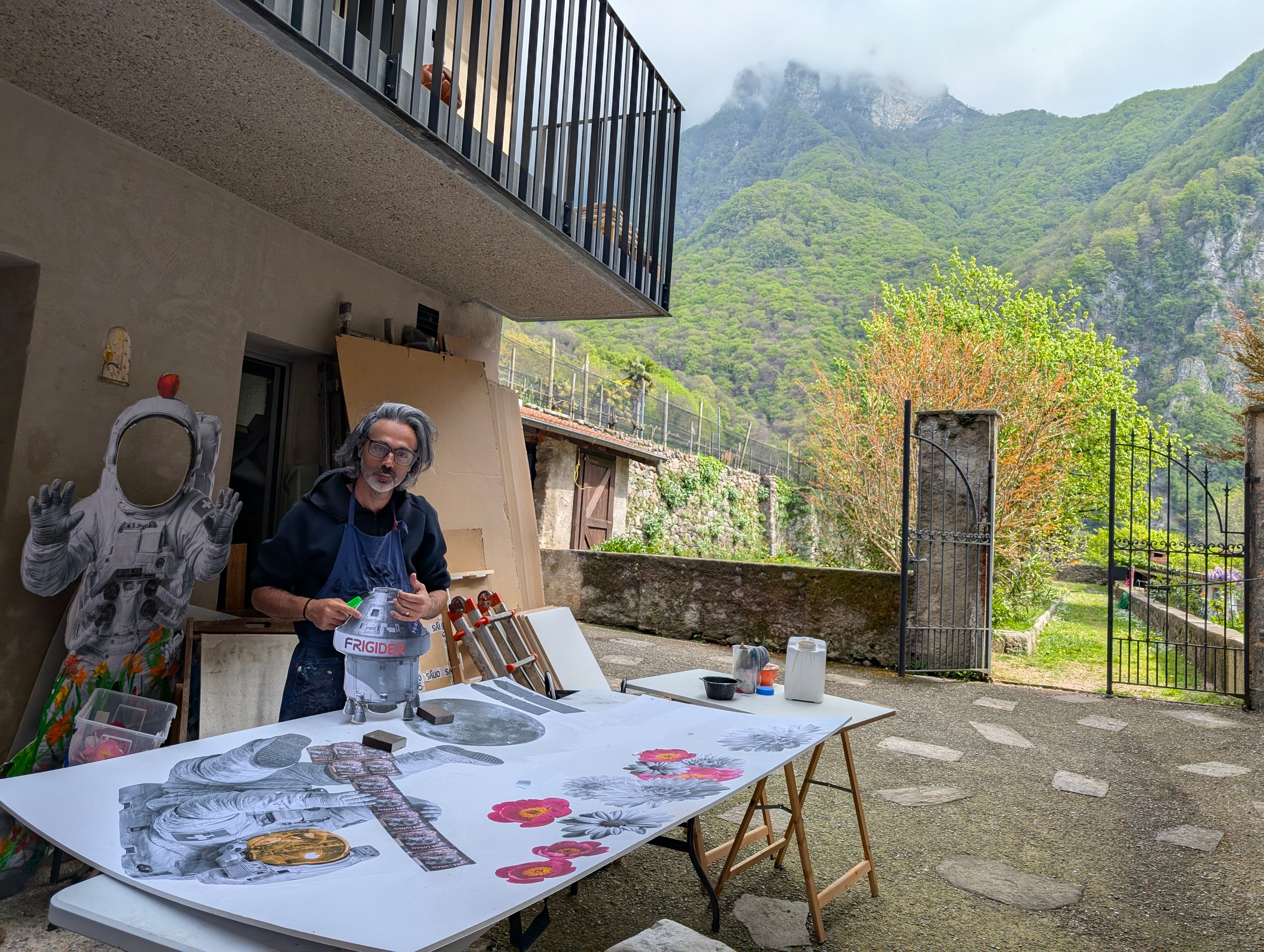 Yuri Catania compone a mano un'opera su carta di grande formato nel cortile dell'atelier di Rovio.